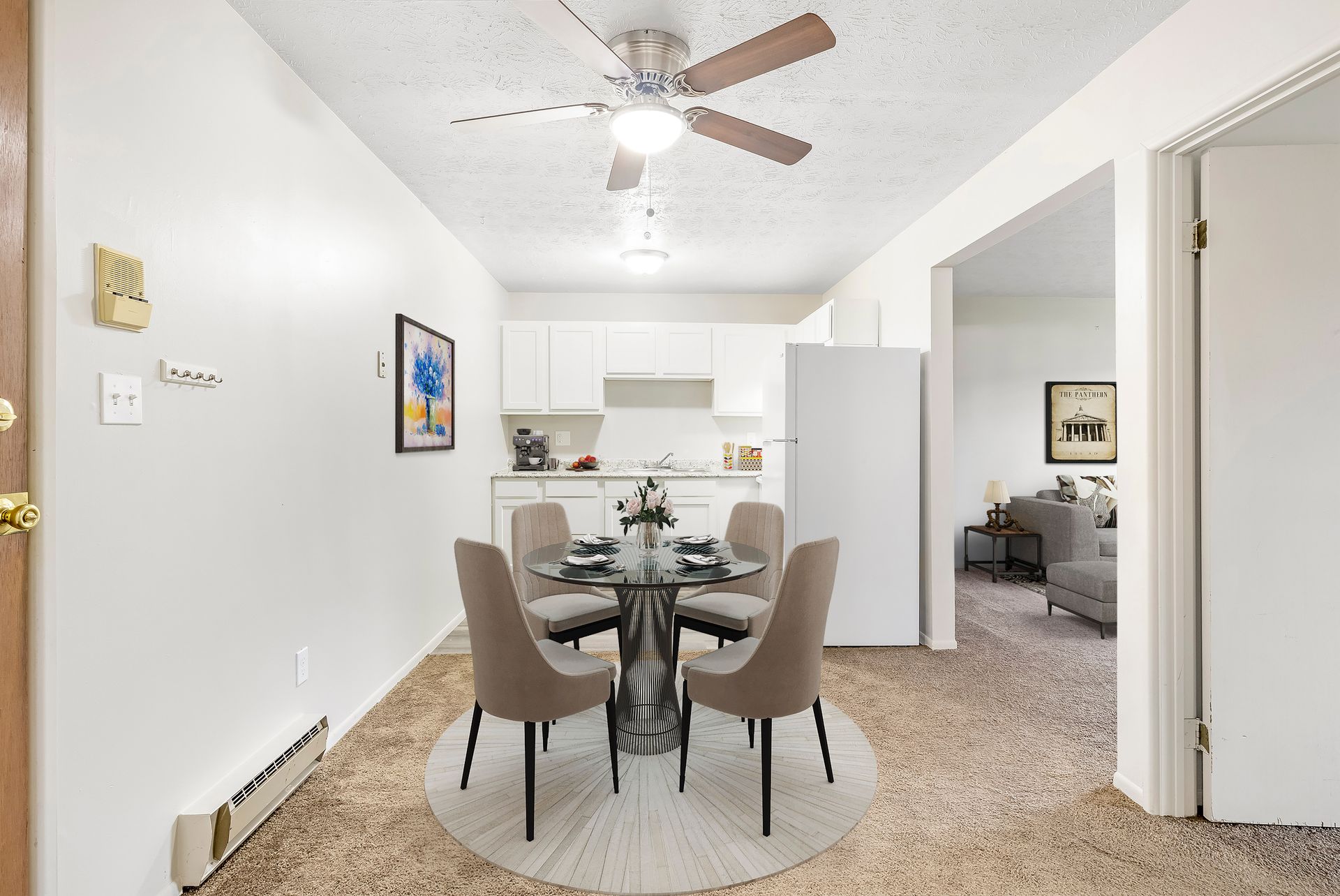 A dining room with a table and chairs and a ceiling fan.
