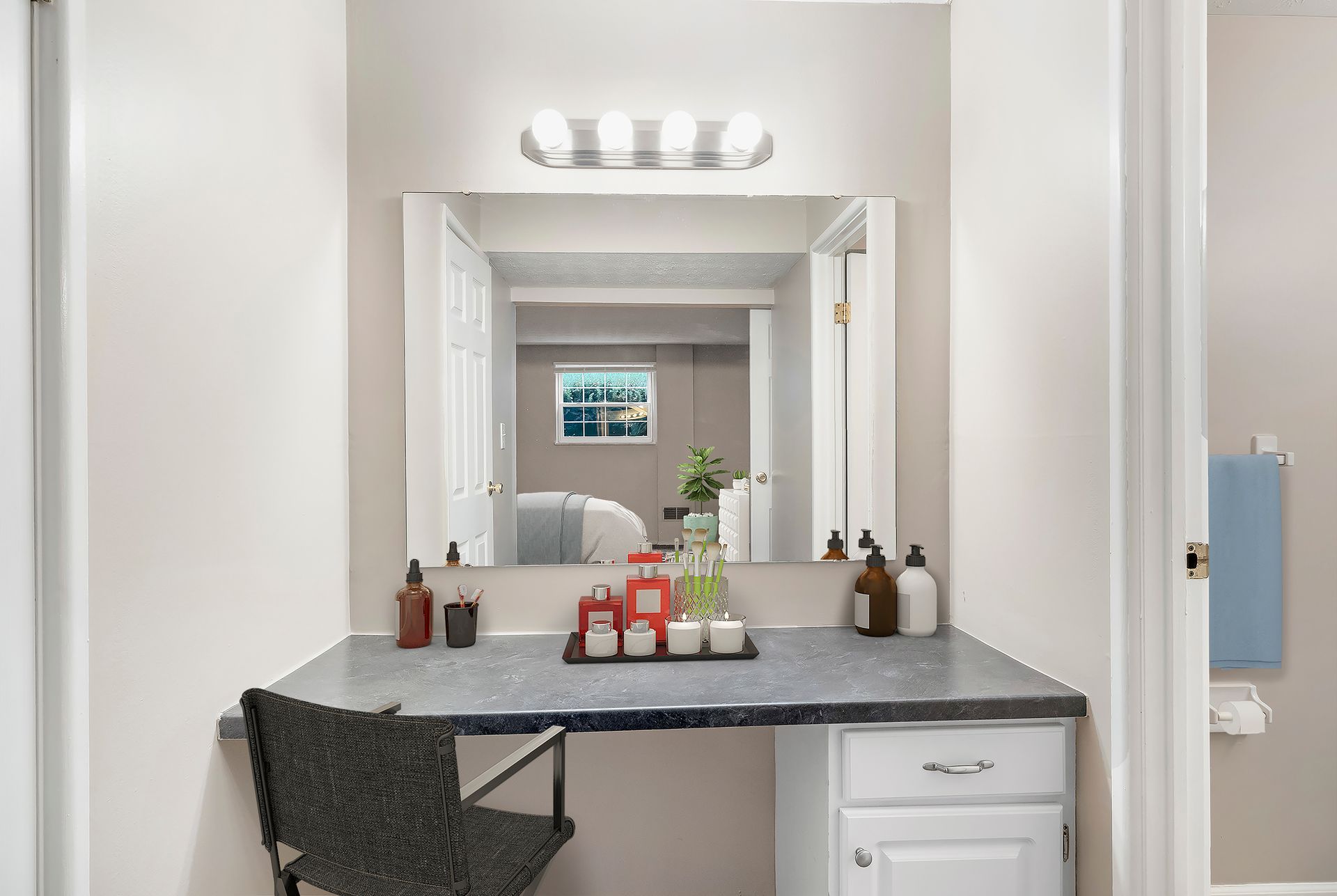 A bathroom with a vanity , mirror and chair.