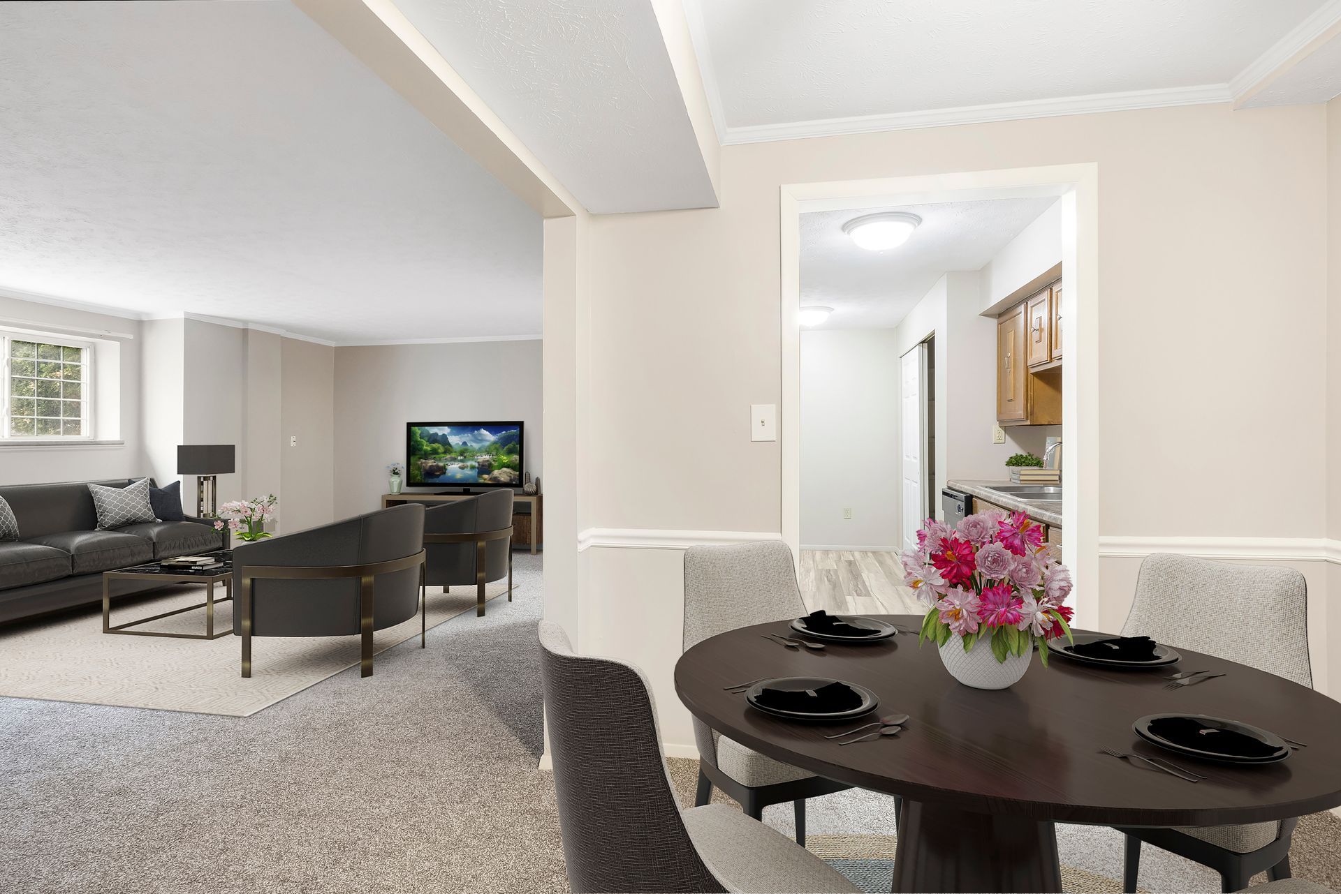 A living room with a dining table and chairs and a television.