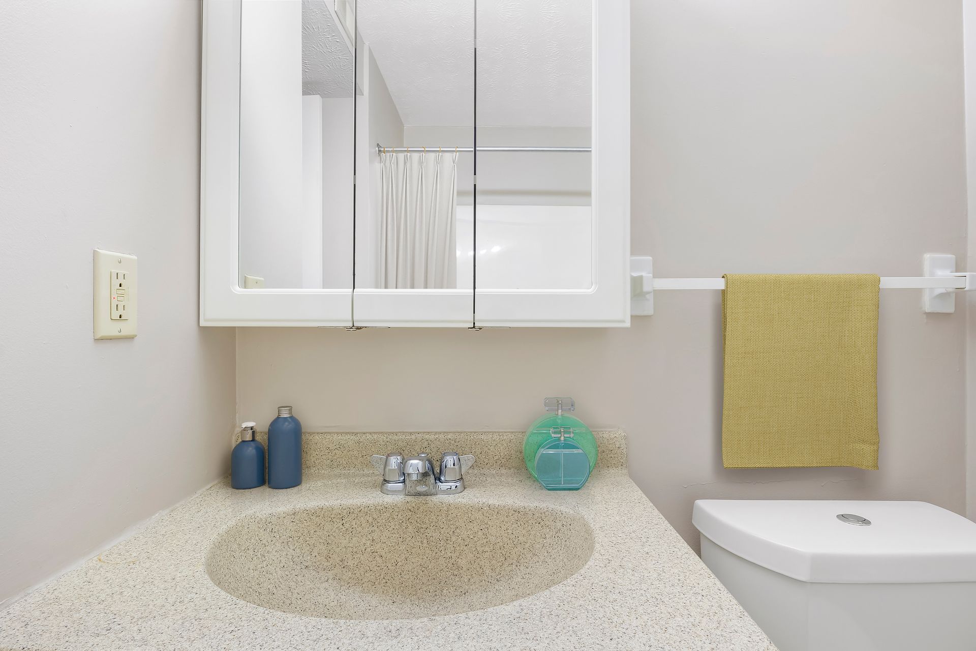 A bathroom with a sink , toilet and mirror.