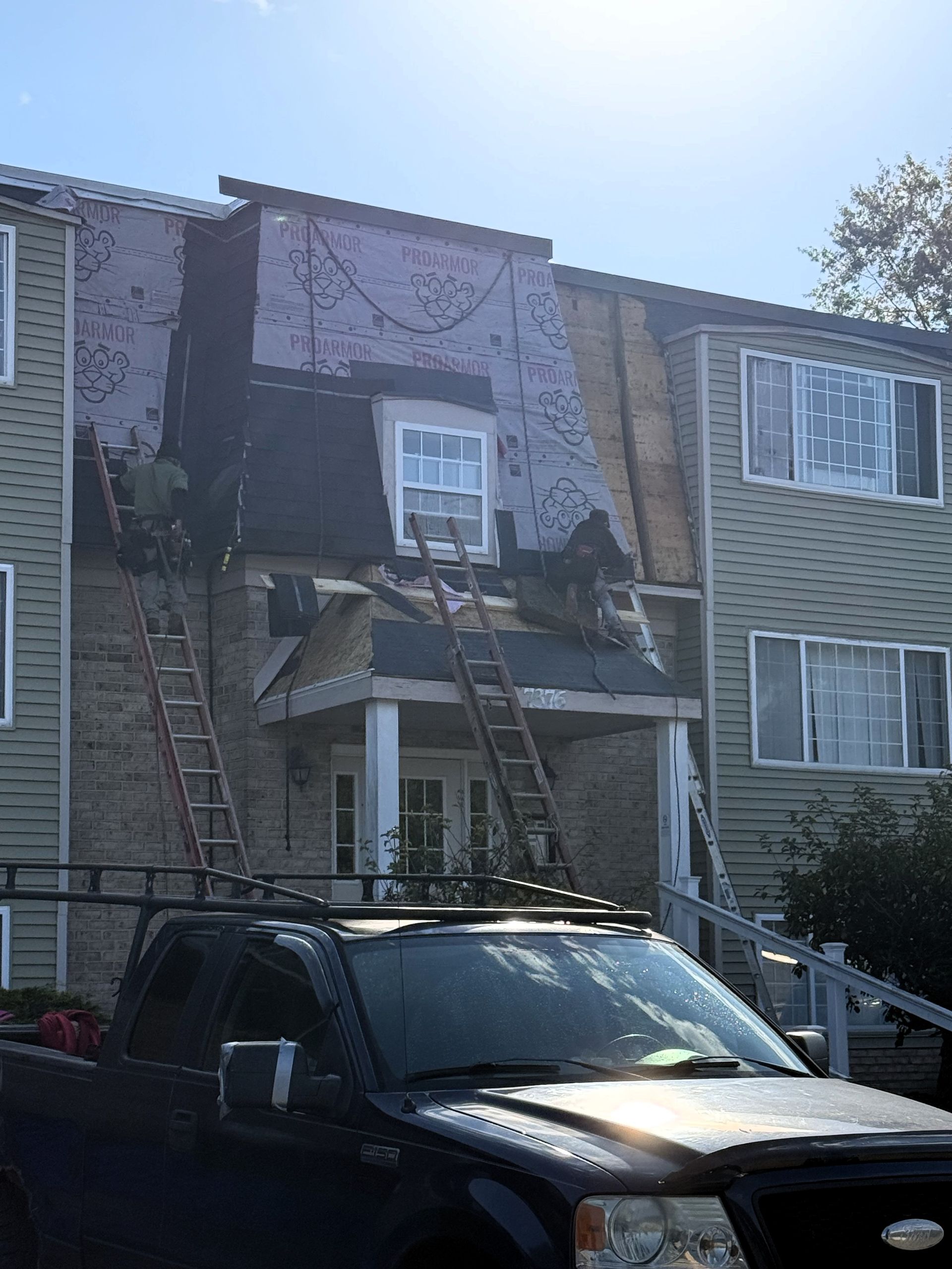 Fire-damaged apartment building with debris and a worker near the entrance