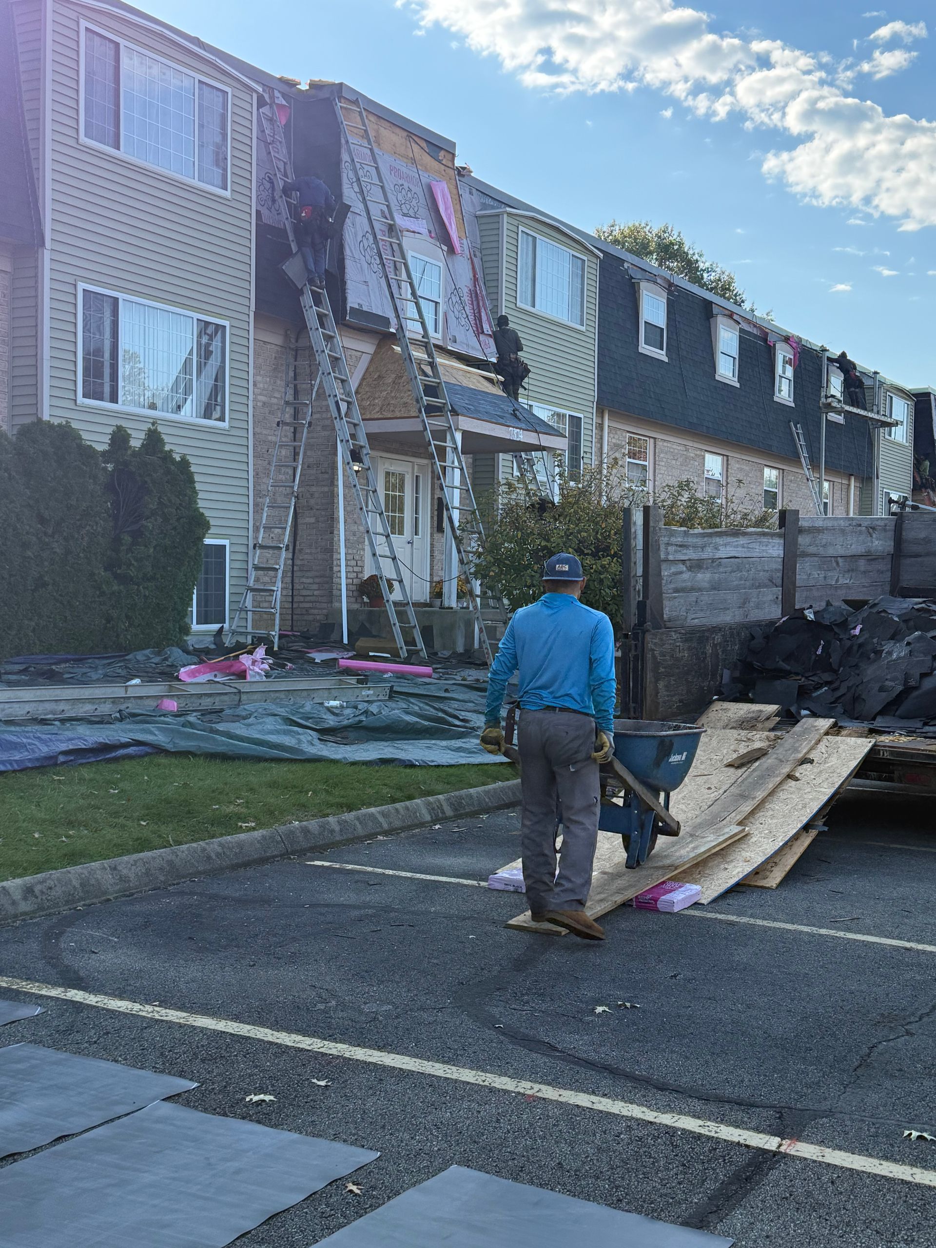 Fire-damaged apartment building with debris and a worker near the entrance