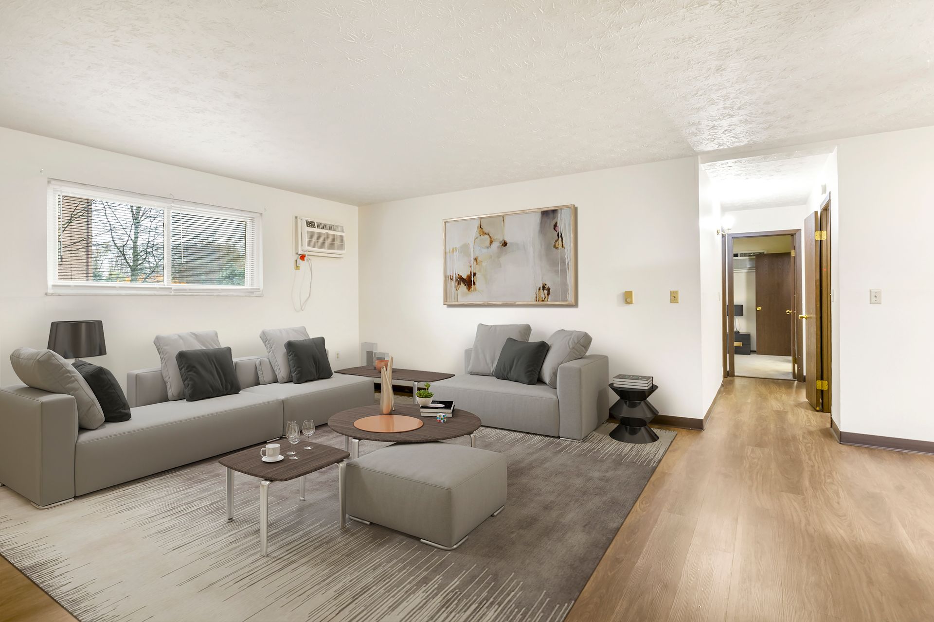 A living room with two couches , a coffee table , and a rug.