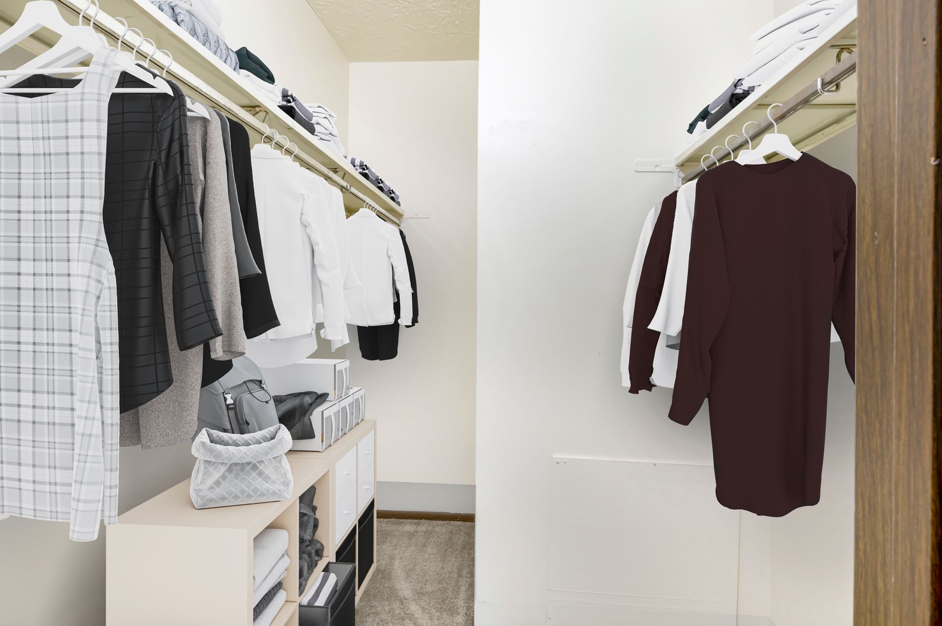 A walk in closet with clothes hanging on racks and shelves.