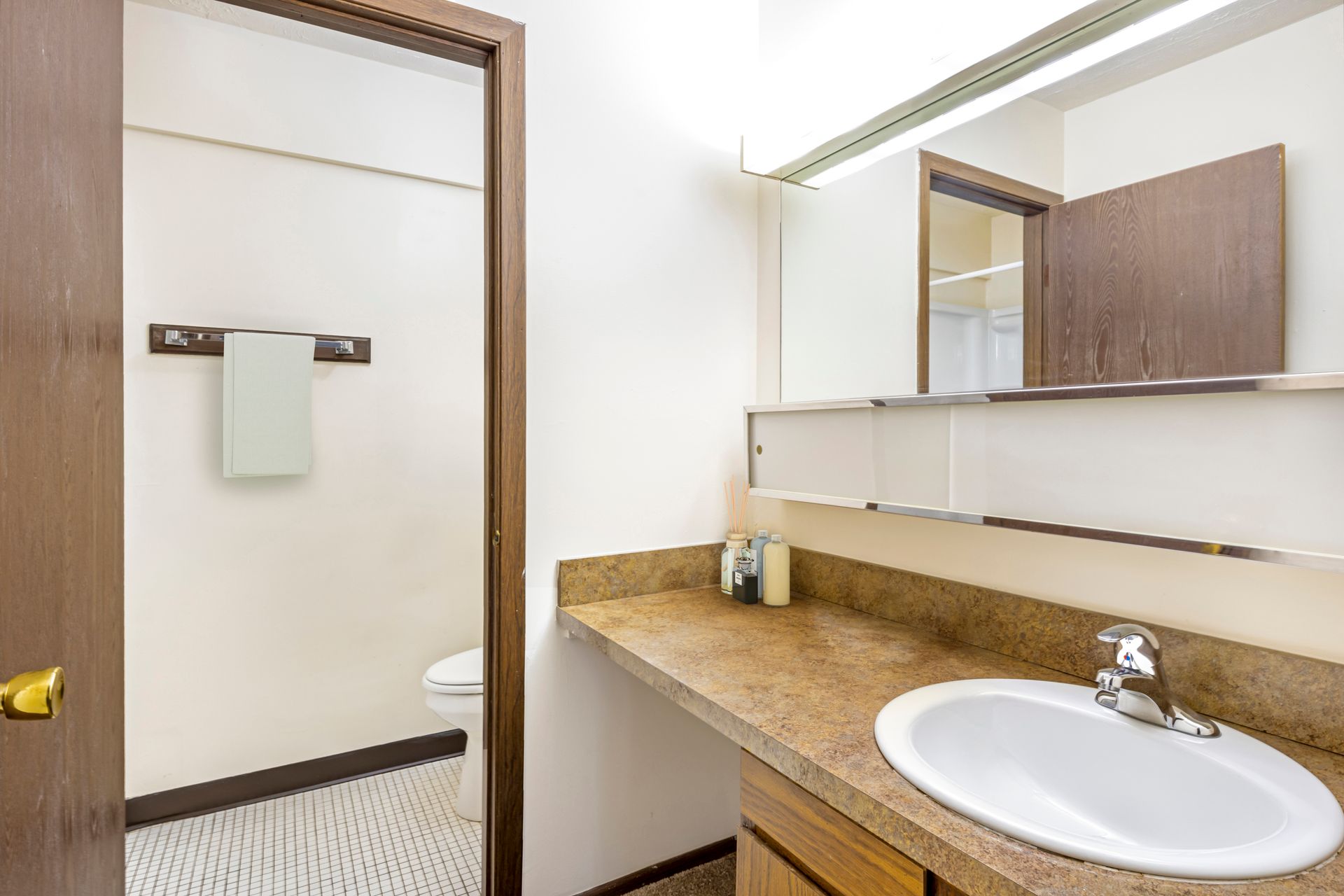 A bathroom with a sink , toilet and mirror.