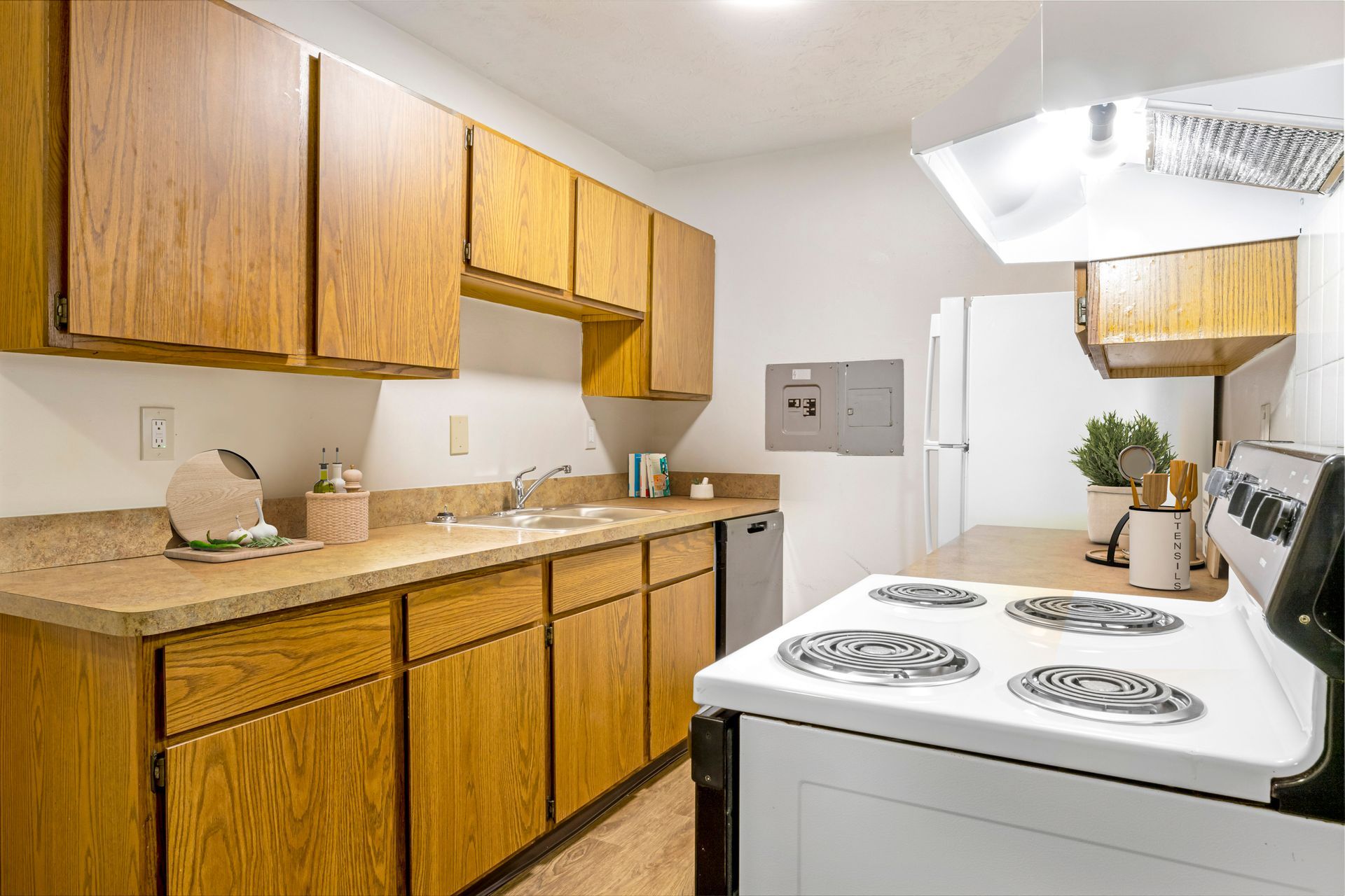 A kitchen with wooden cabinets and a white stove