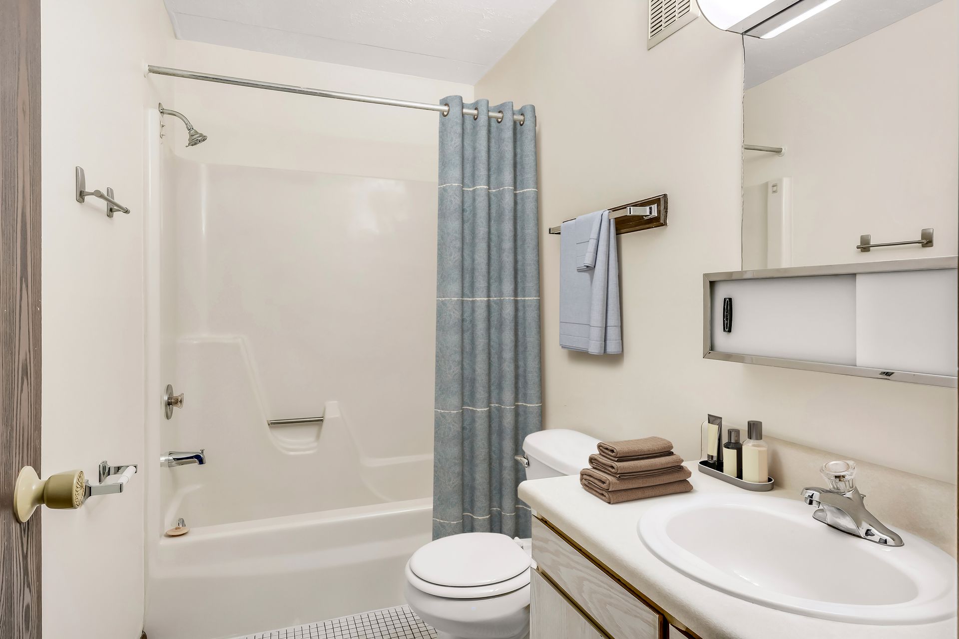 A bathroom with a toilet , sink , tub and shower.