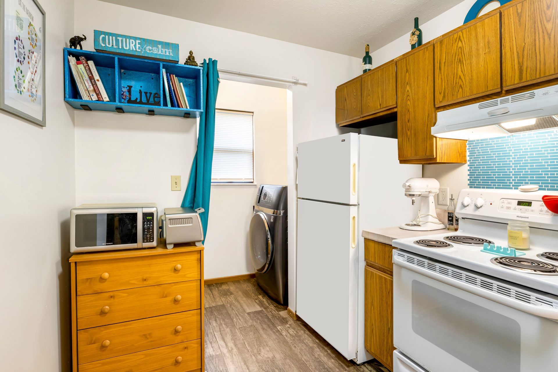 A kitchen with a refrigerator , stove , microwave , and dresser.