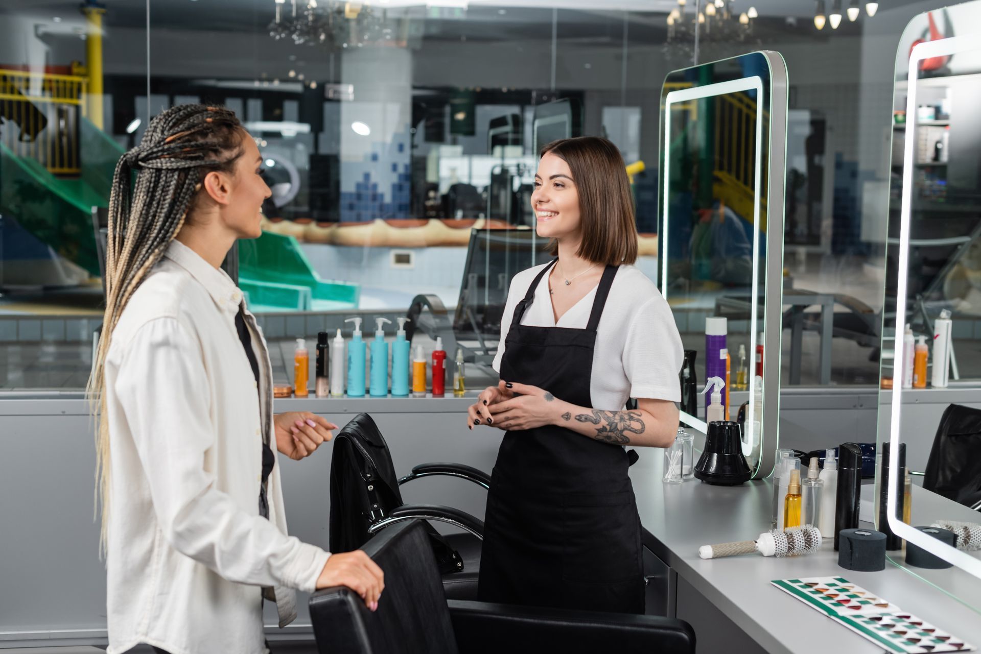 Two women are talking to each other in a hair salon.