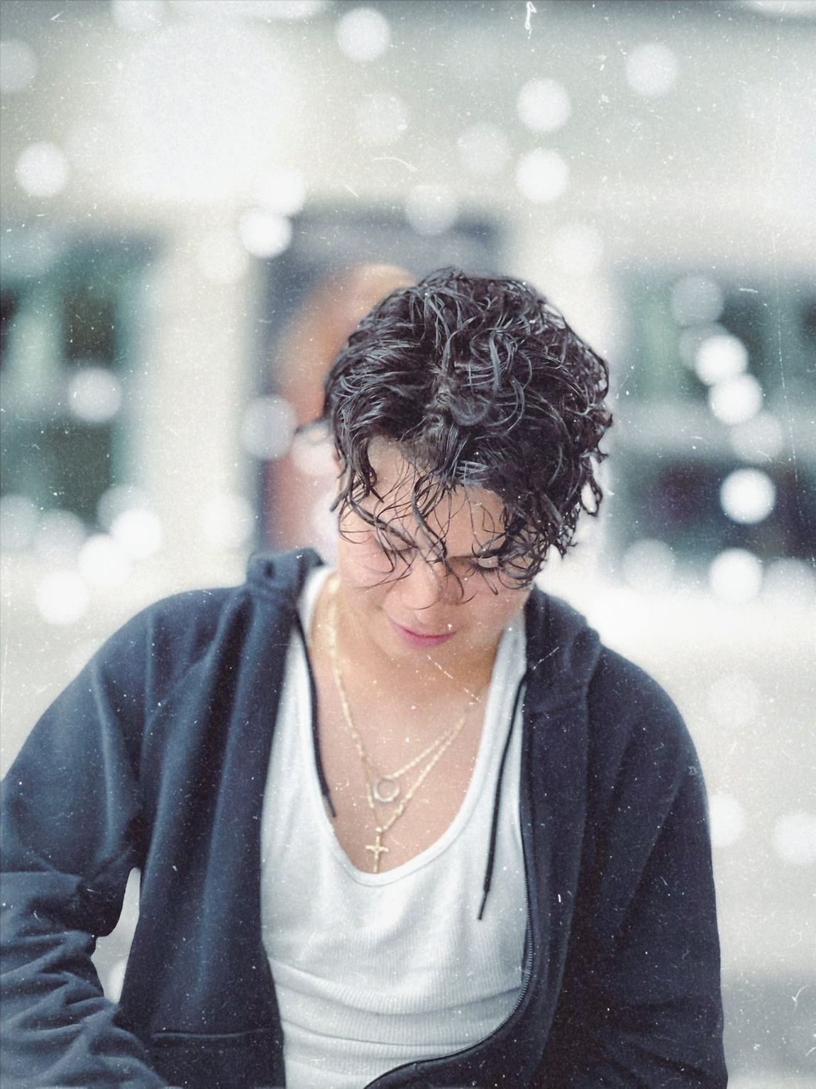 A man with curly hair wearing glasses and a black jacket
