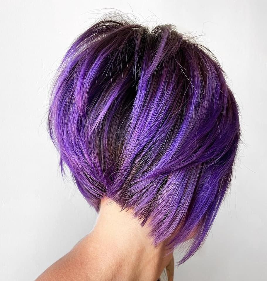 The back of a woman 's head with purple hair.