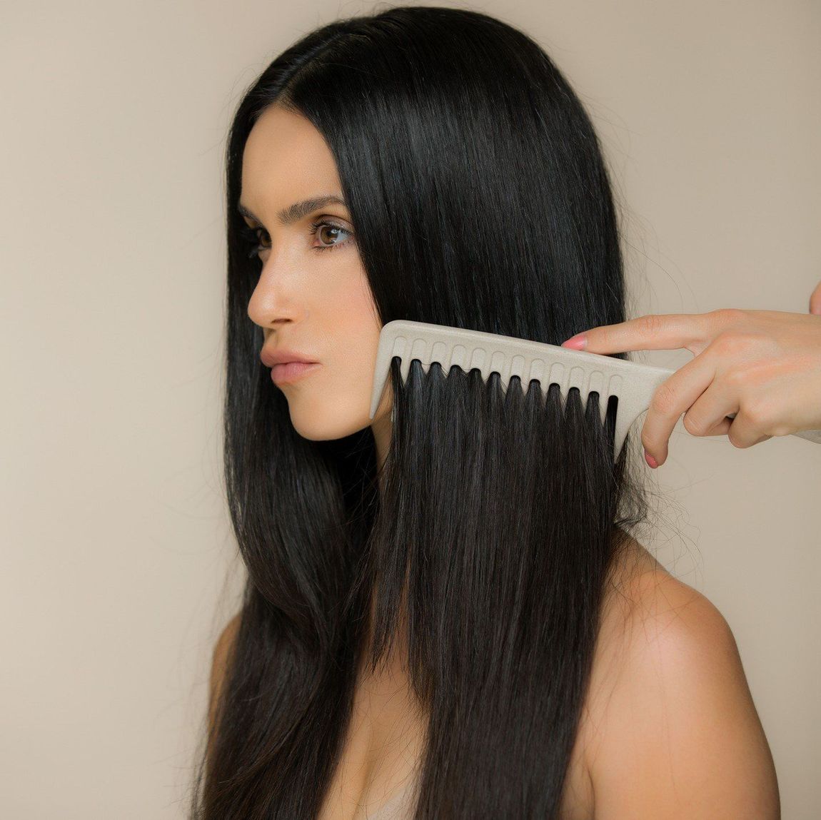 A woman is being combed with a white comb.