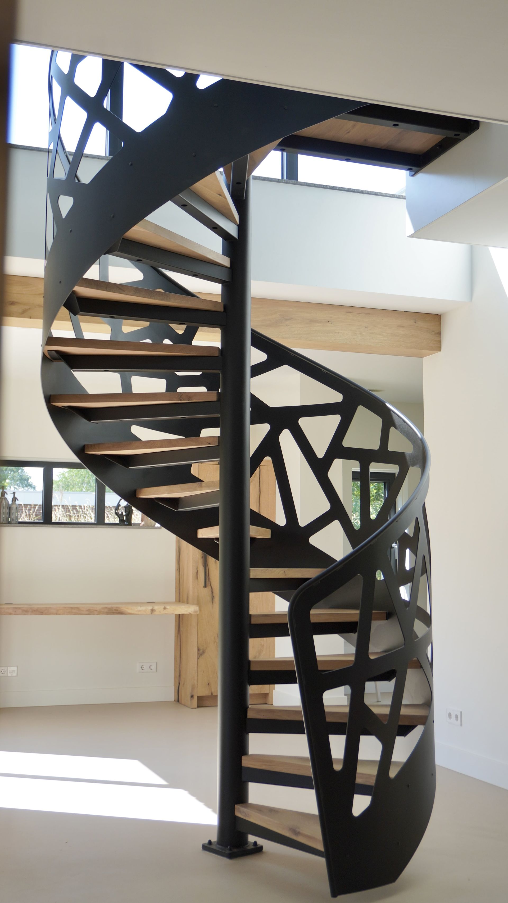 Stalen wenteltrap of spiltrap met eiken treden en stalen balustrade met of zonder glas. Op maat gemaakt door Hollemans Homesteel uit Numansdorp