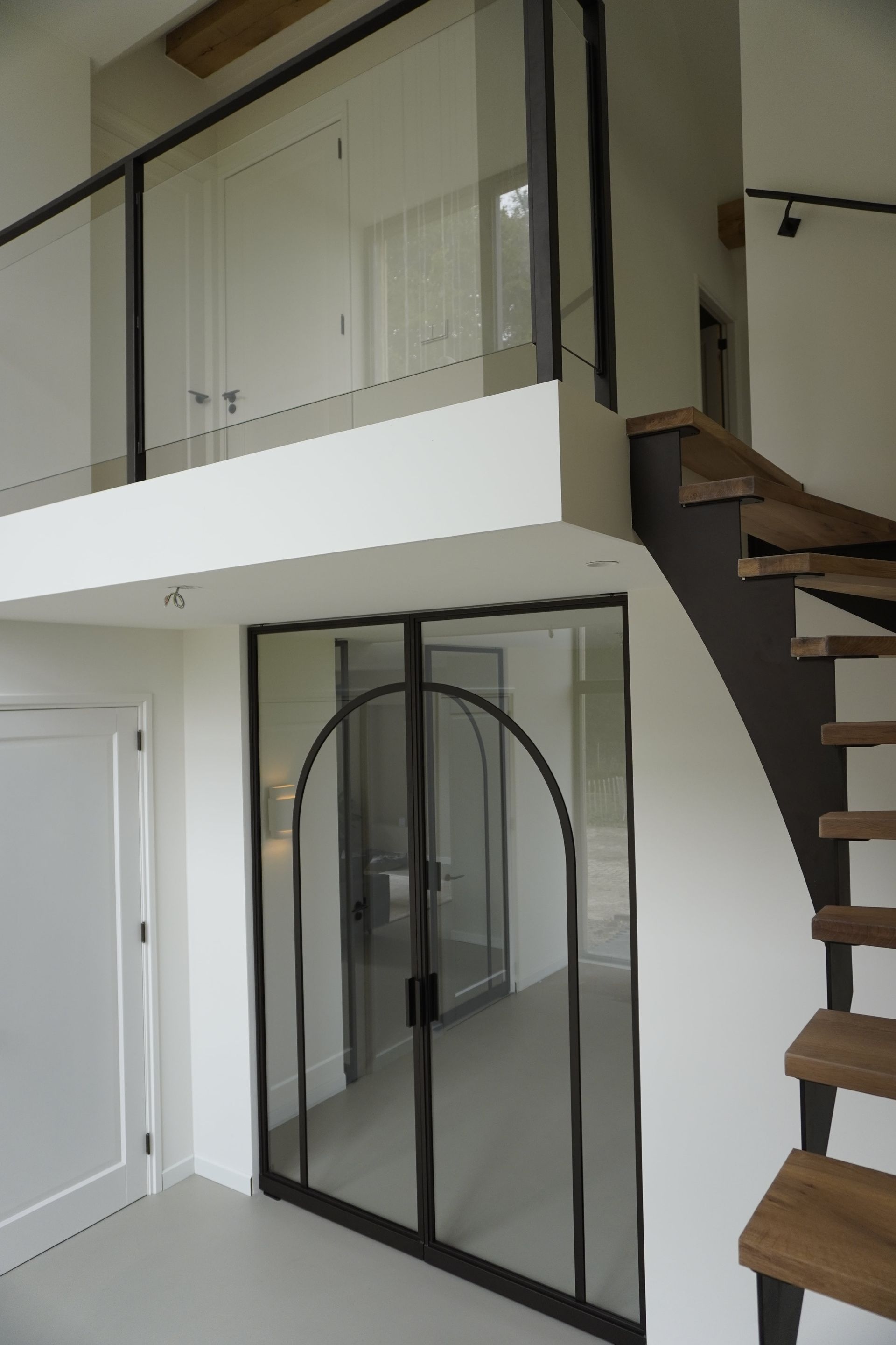Stalen maatwerk trap met eikenhouten treden en glazen balustrade door Hollemans Homesteel uit Numansdorp
