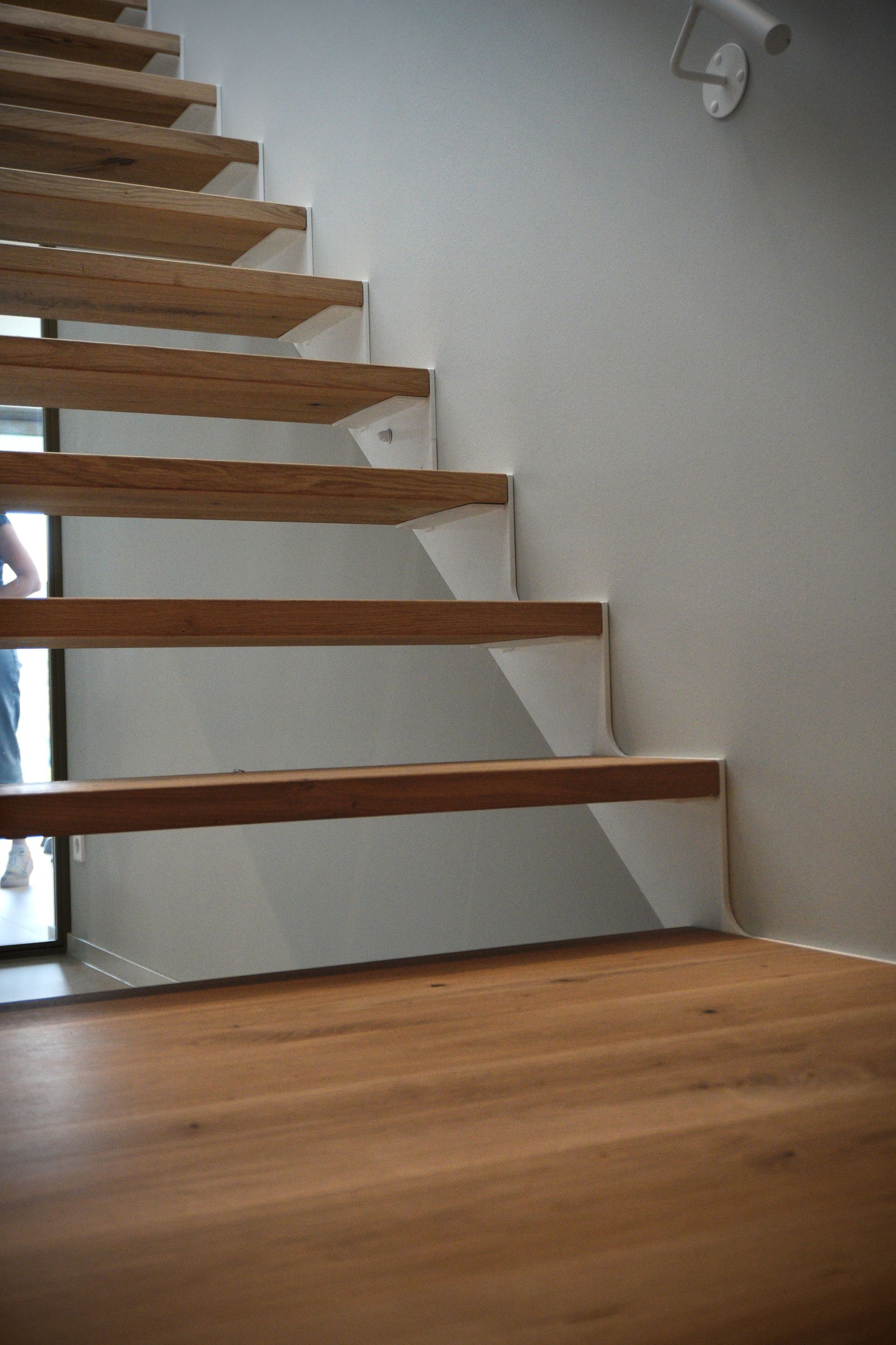 Witte stalen trap strak design met licht eiken treden op maat gemaakt door Hollemans Homesteel uit Numansdorp