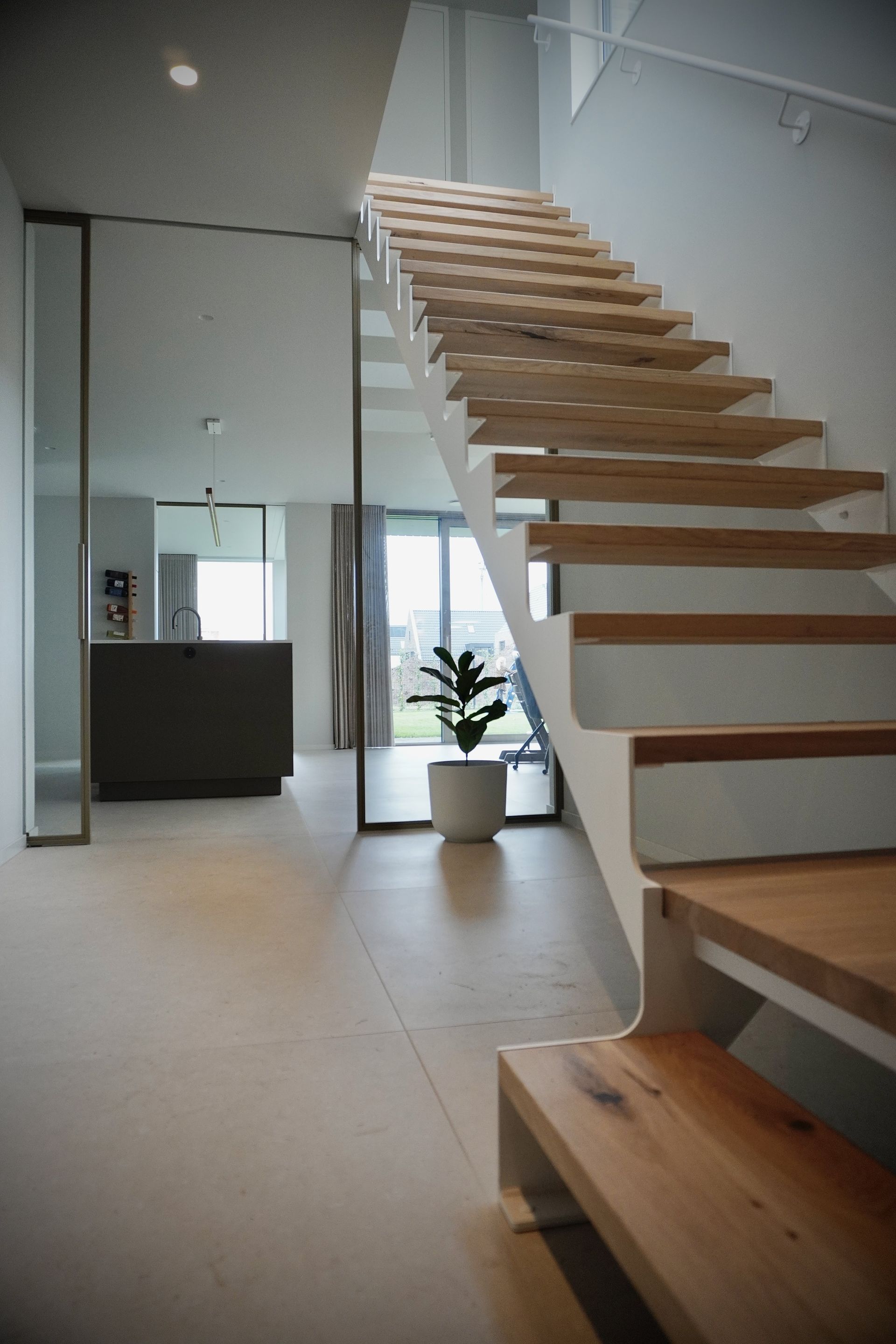 Witte stalen trap strak design met licht eiken treden op maat gemaakt door Hollemans Homesteel uit Numansdorp