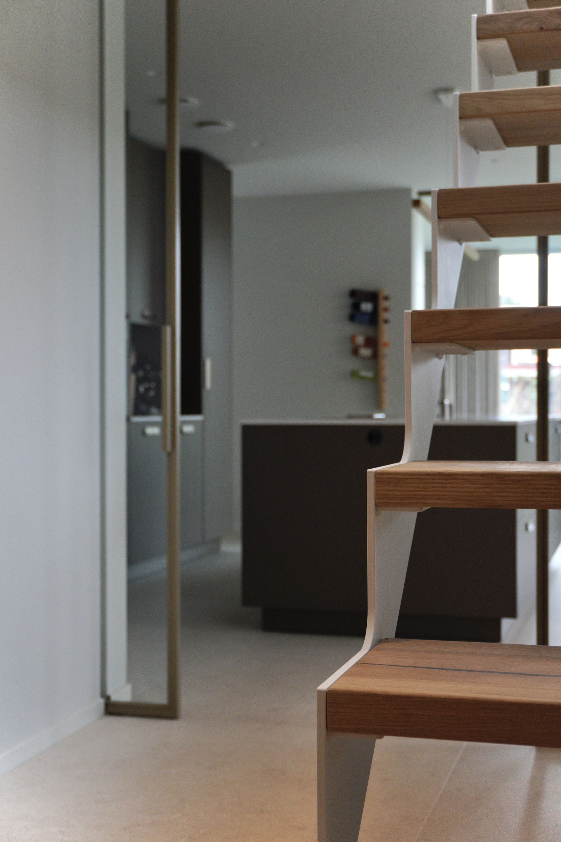 Witte stalen trap strak design met licht eiken treden op maat gemaakt door Hollemans Homesteel uit Numansdorp