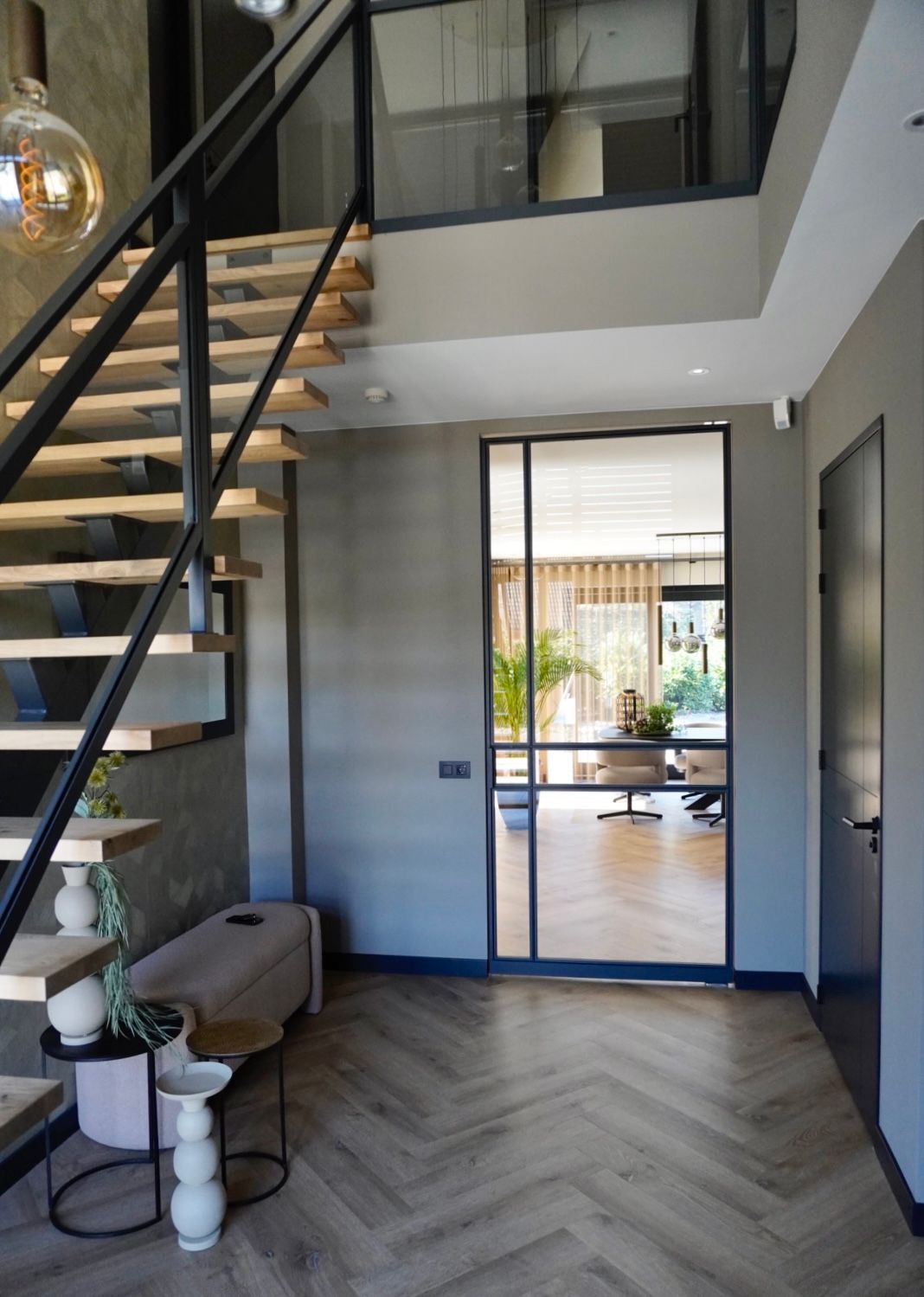 Stalen maatwerk trap met eikenhouten treden en glazen balustrade door Hollemans Homesteel uit Numansdorp