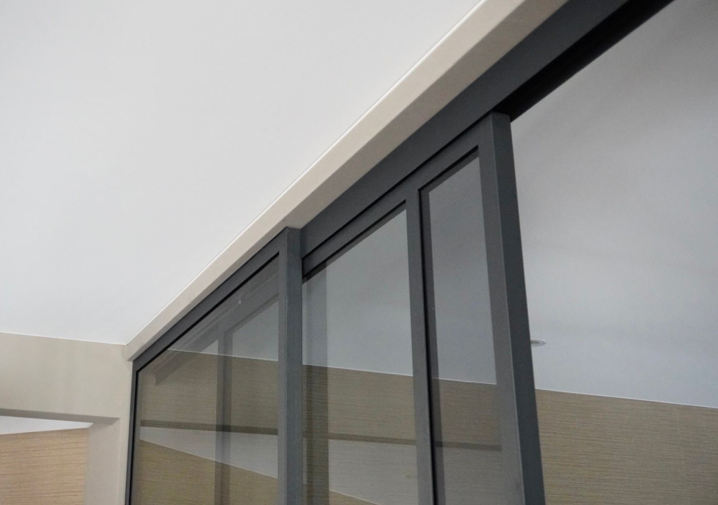 Stalen schuifdeuren met glas, uitgevoerd met een soft-close systeem.