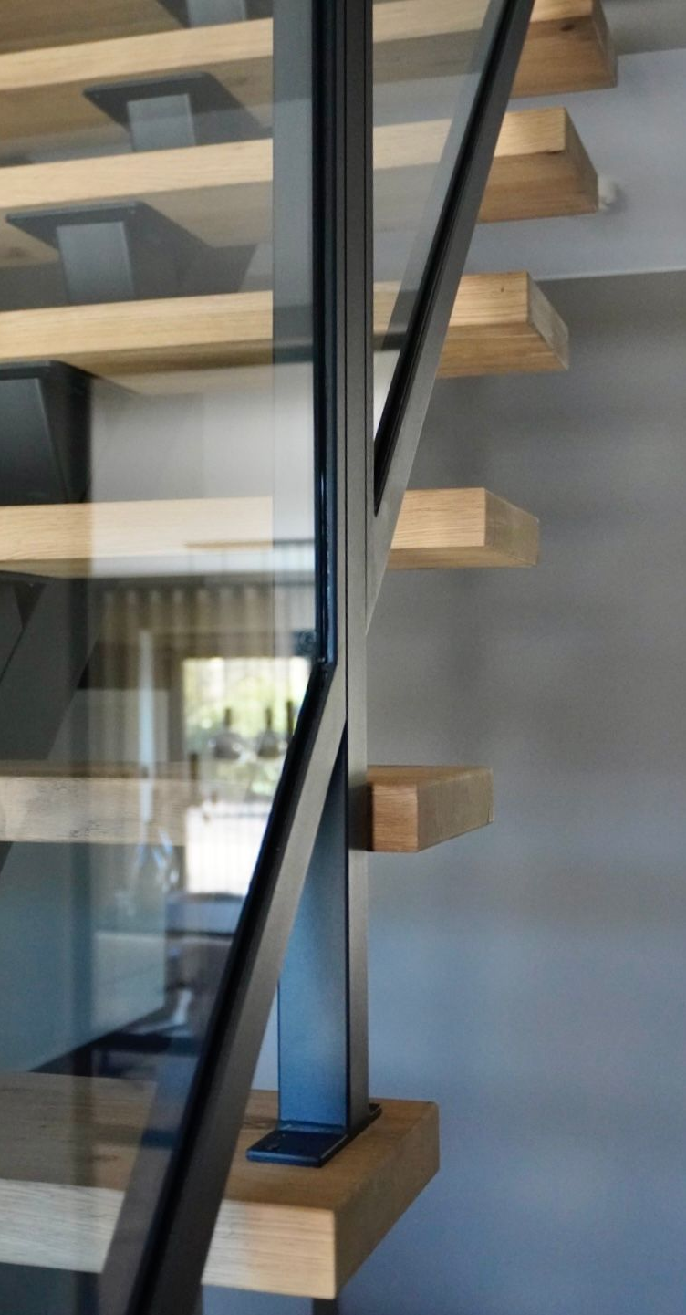 Stalen midden-boom trap met glazen balustrade en eiken treden