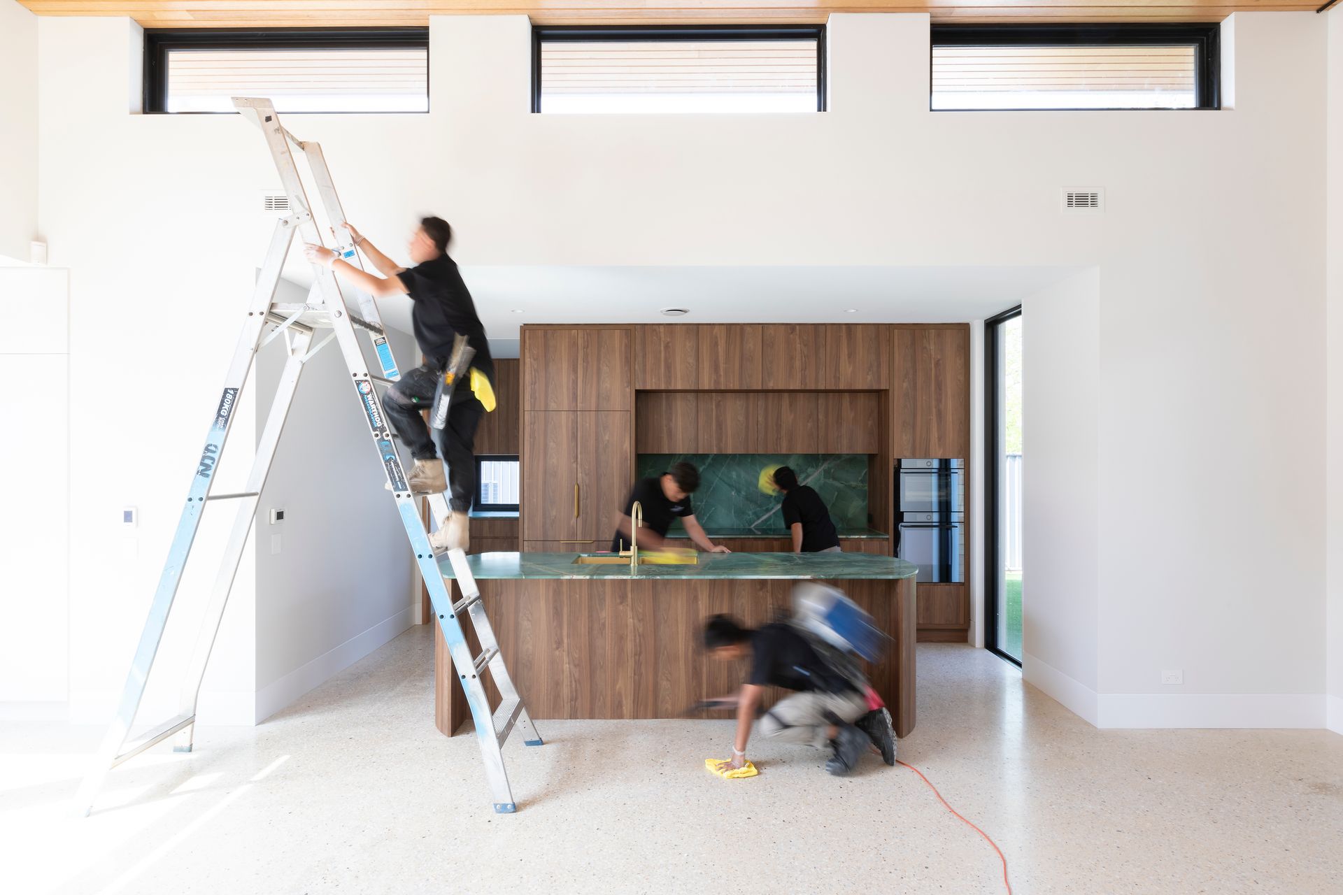 A group of men are working on a kitchen in a house.