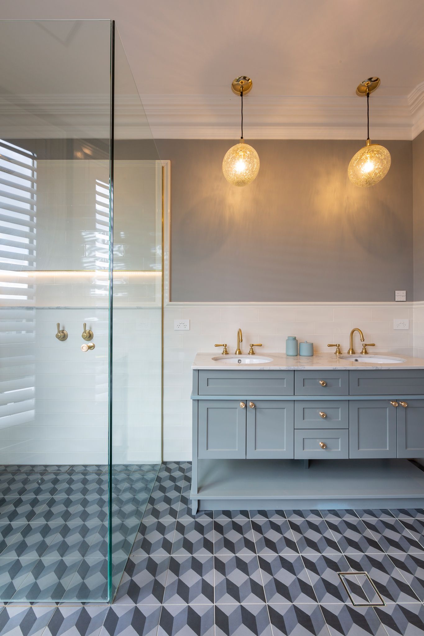 A bathroom with two sinks and a walk in shower.