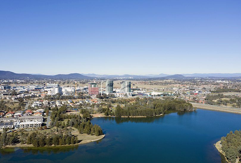 An aerial view of a lake with a city in the background