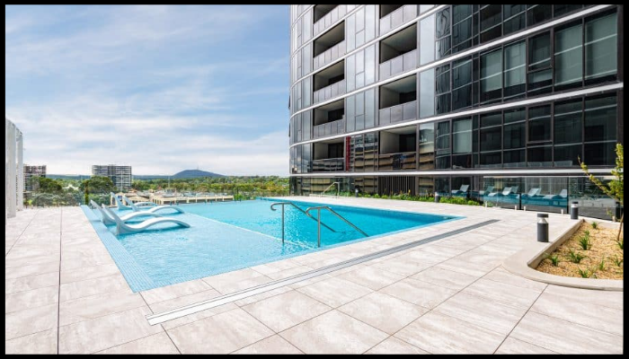 There is a large swimming pool in front of a building.
