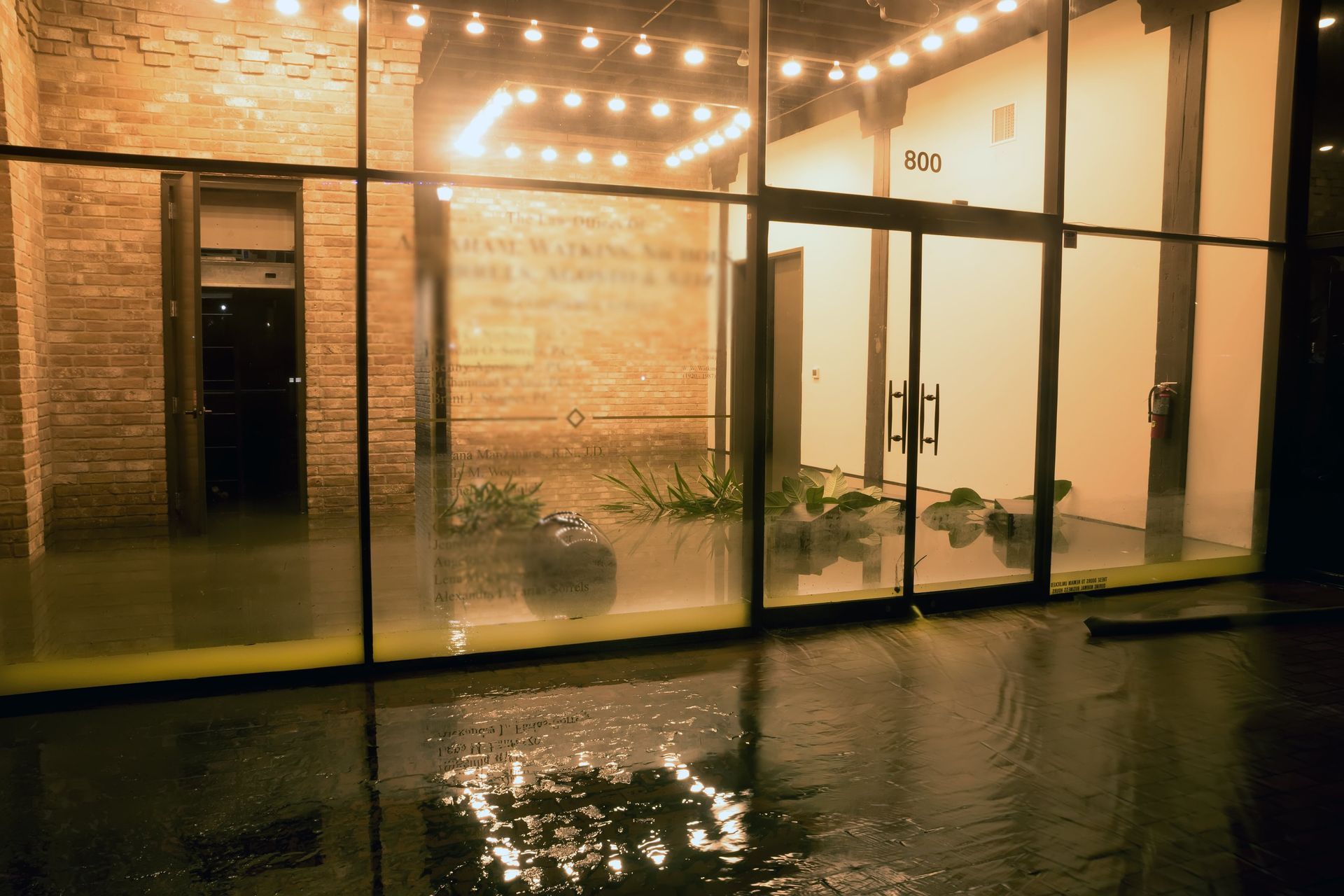 A flooded building with a lot of water coming out of the windows