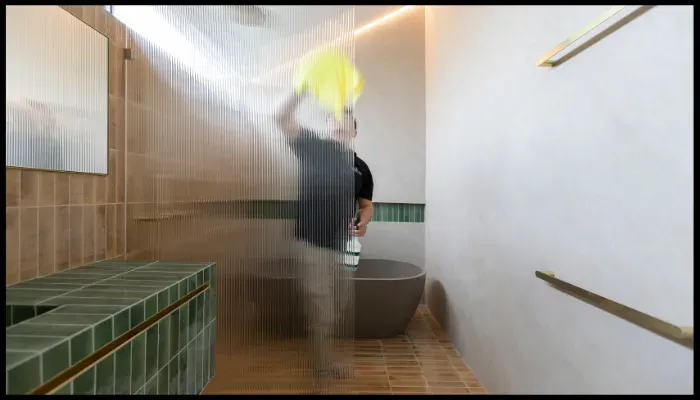 A person is cleaning a wall with a spray bottle and a cloth.
