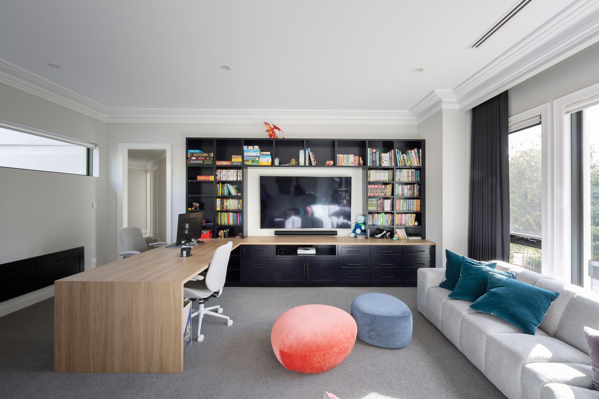 A living room with a couch , desk , television and bookshelves.