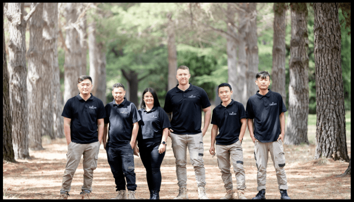 A group of people standing next to each other in a forest.