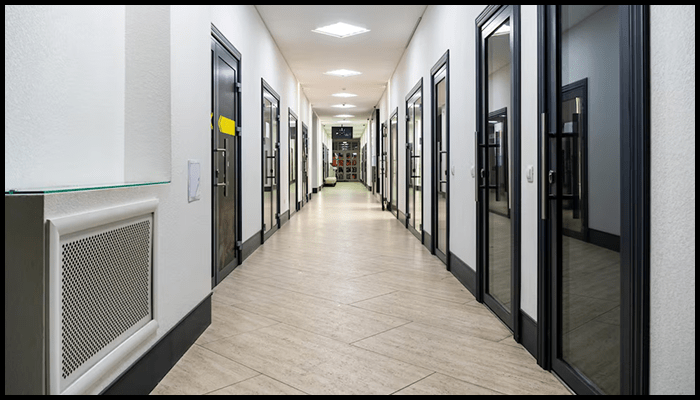 Modern shared hallway in a strata-managed commercial or residential building with clean, reflective surfaces.