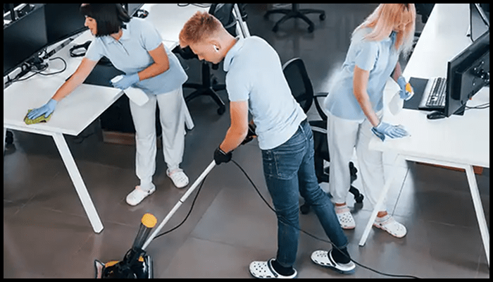 Team of professional cleaners performing regular maintenance in a shared commercial office space