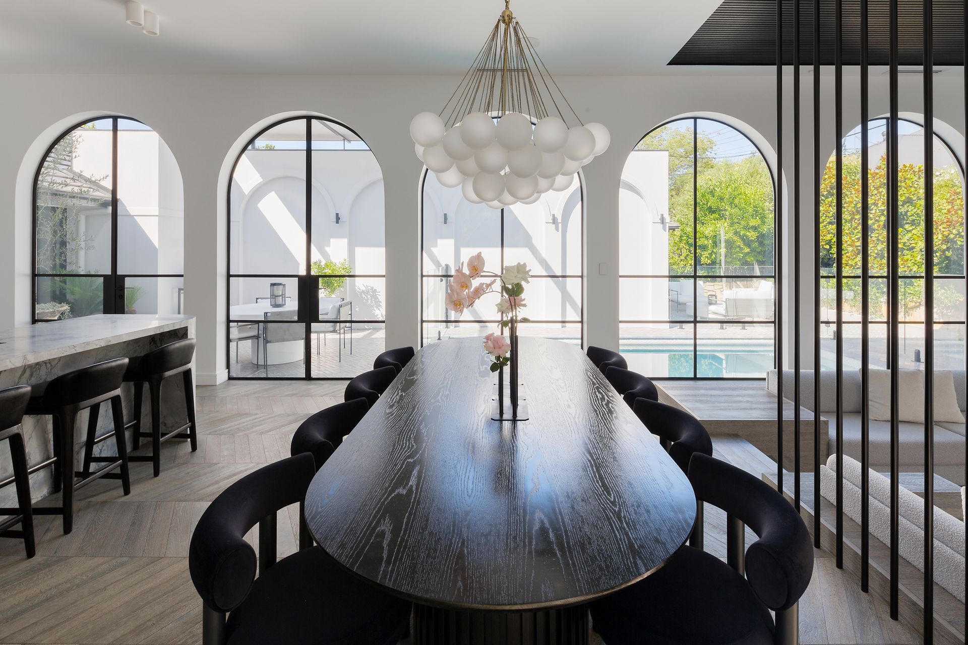 A dining room with a long table and chairs and a chandelier.