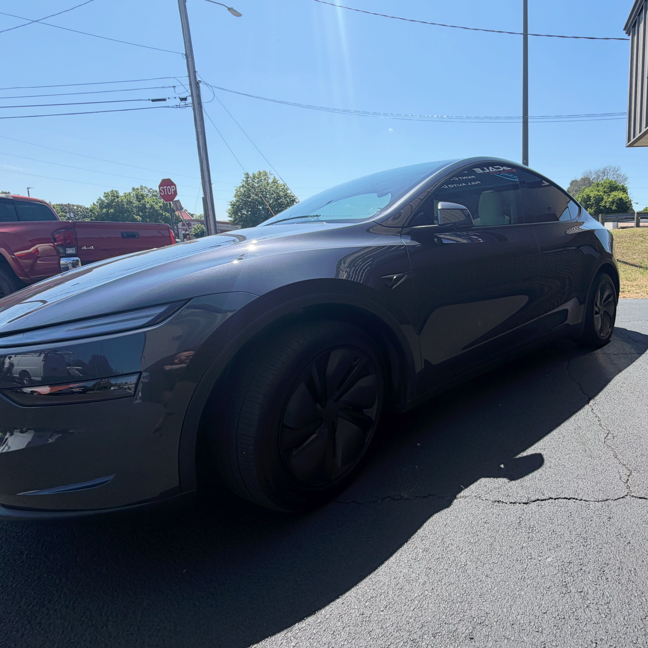 Black sports car parked outside a brick building on a sunny day