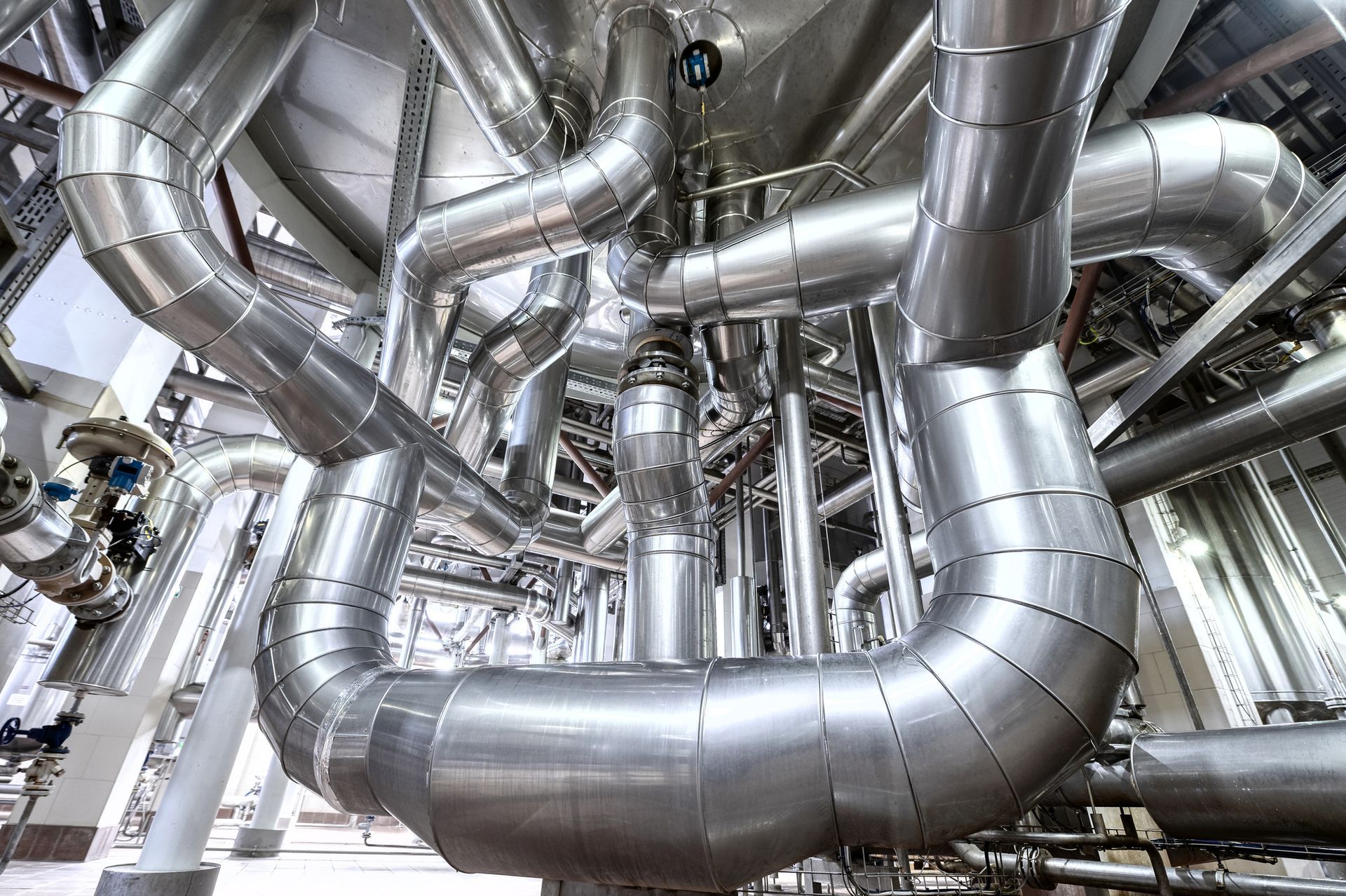 A bunch of metal pipes are connected to each other in a factory.