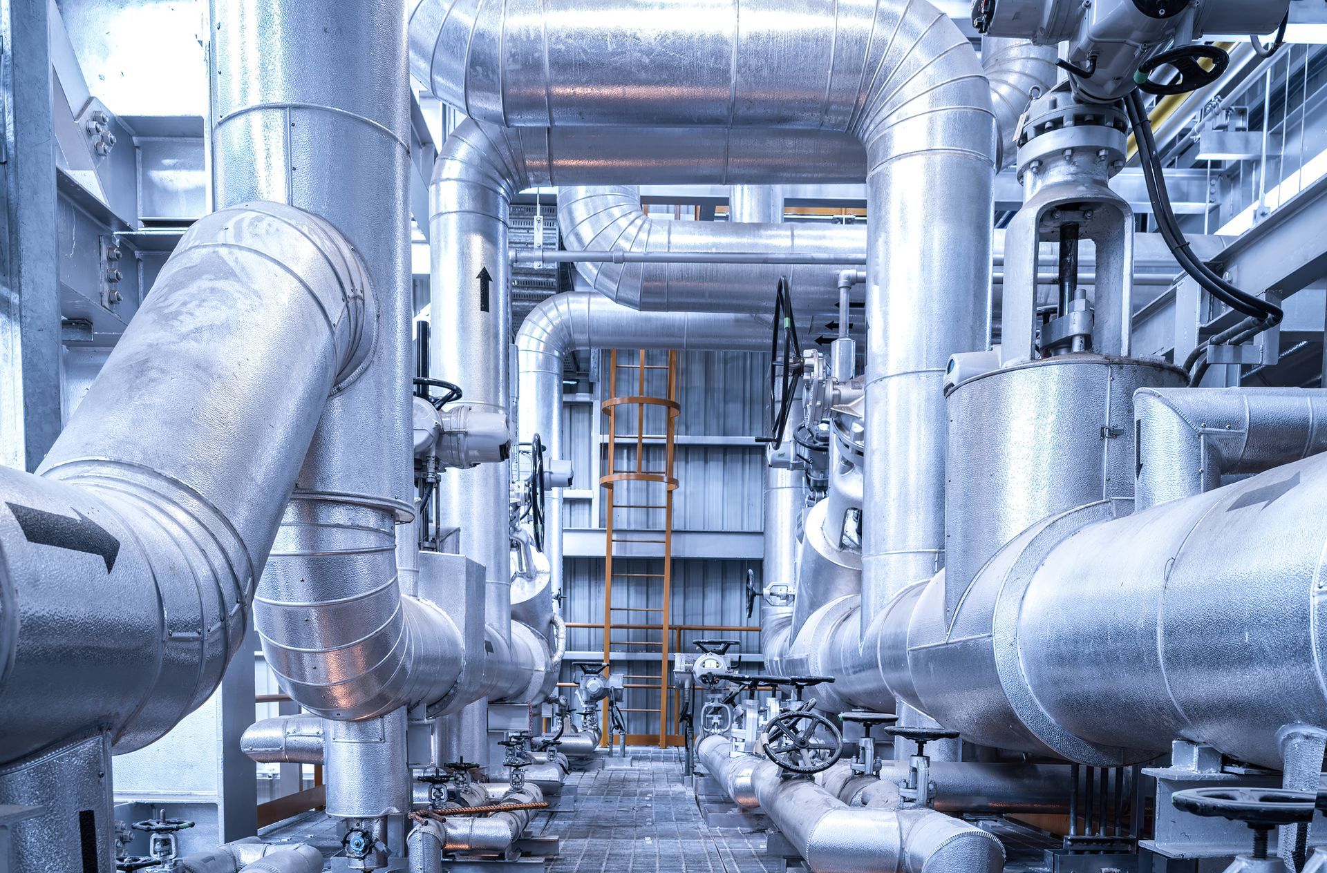 A blue building with a lot of pipes on it.