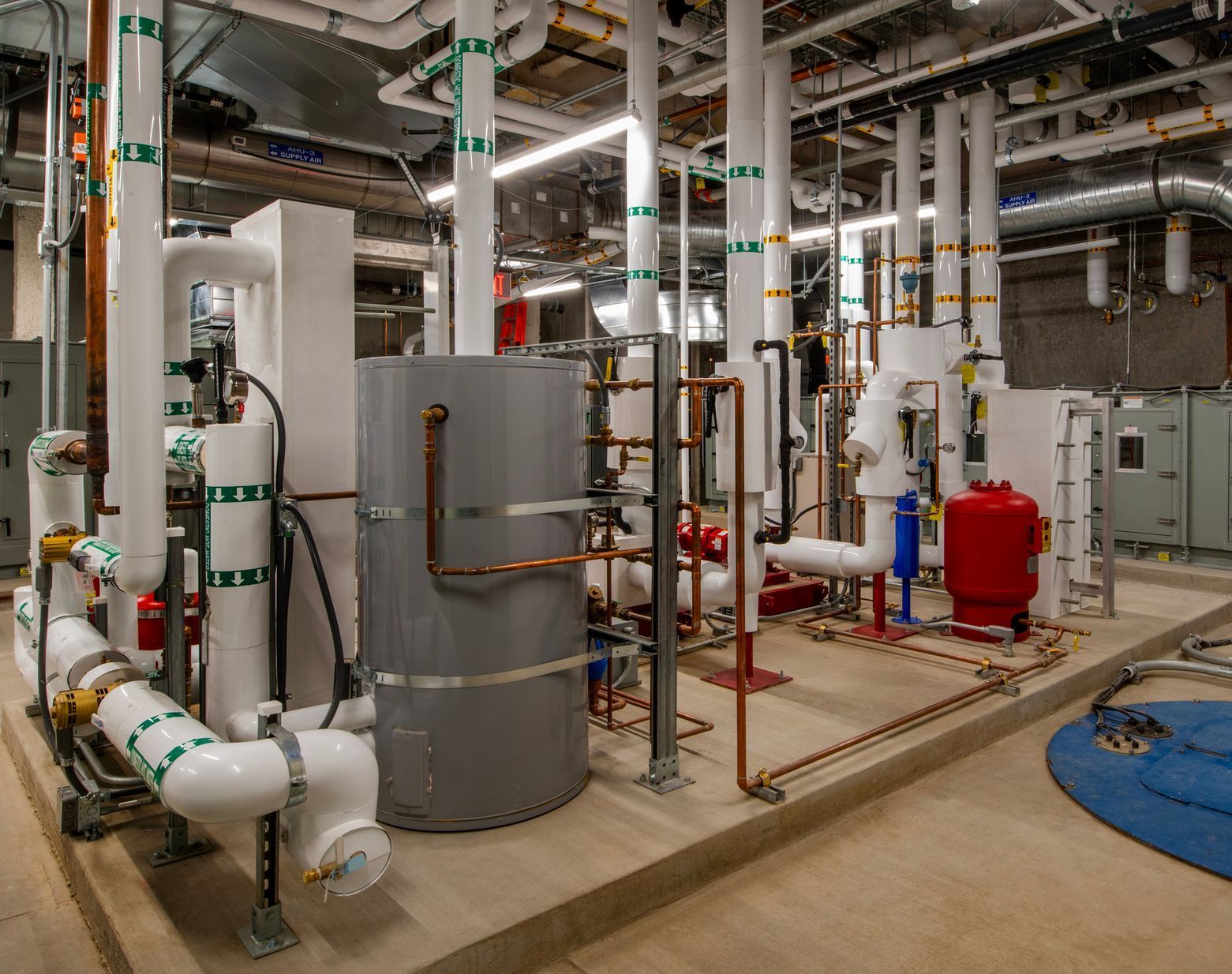 A bunch of pipes are hanging from the ceiling of a building.