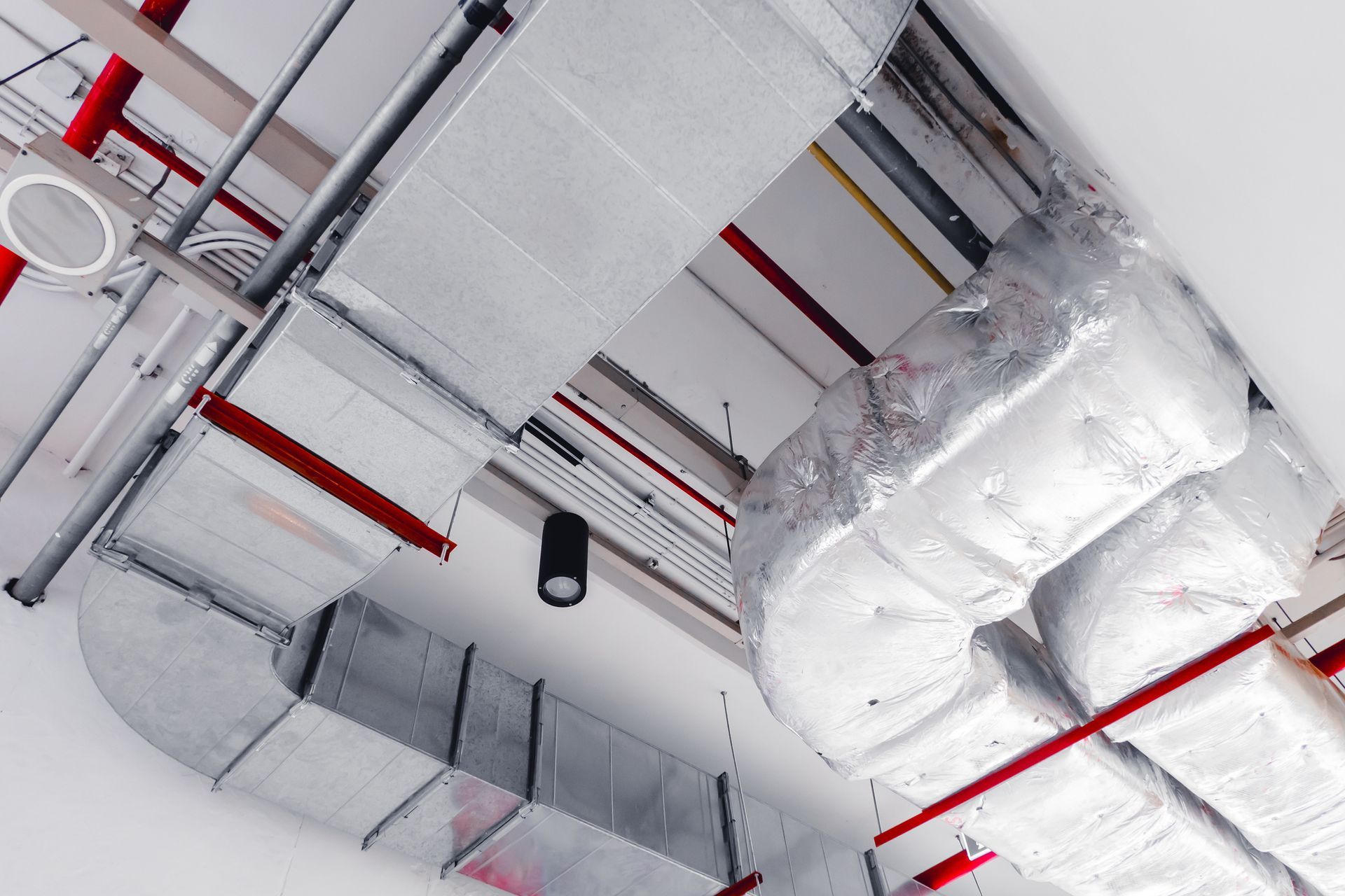 A room with a lot of pipes hanging from the ceiling.