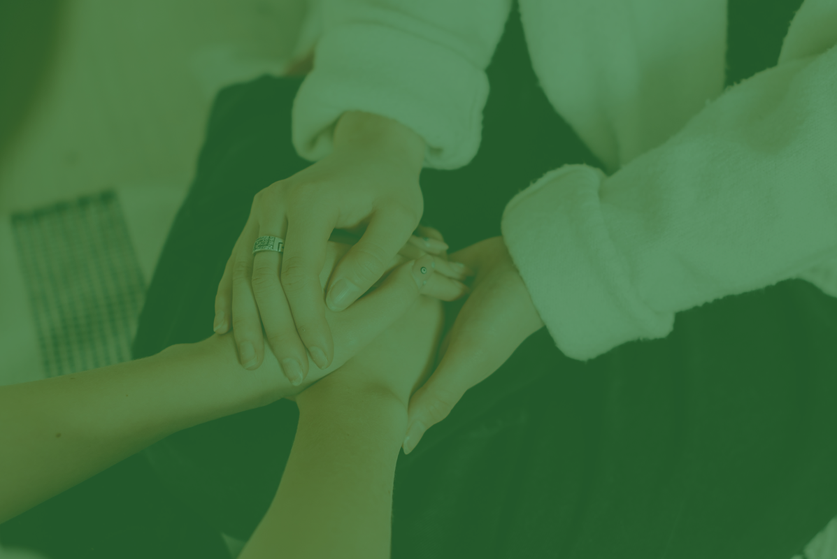Hands clasped together, possibly in support or unity; light green hue.
