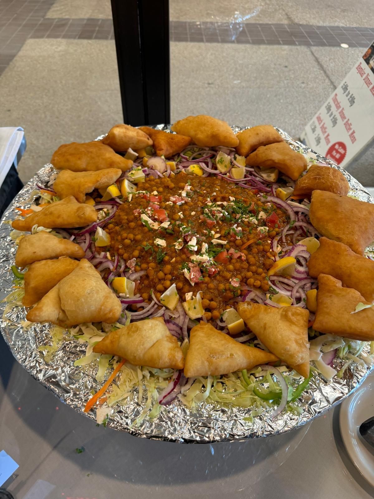 Platter of fried appetizers arranged around a colorful sauced dip, topped with chopped herbs.