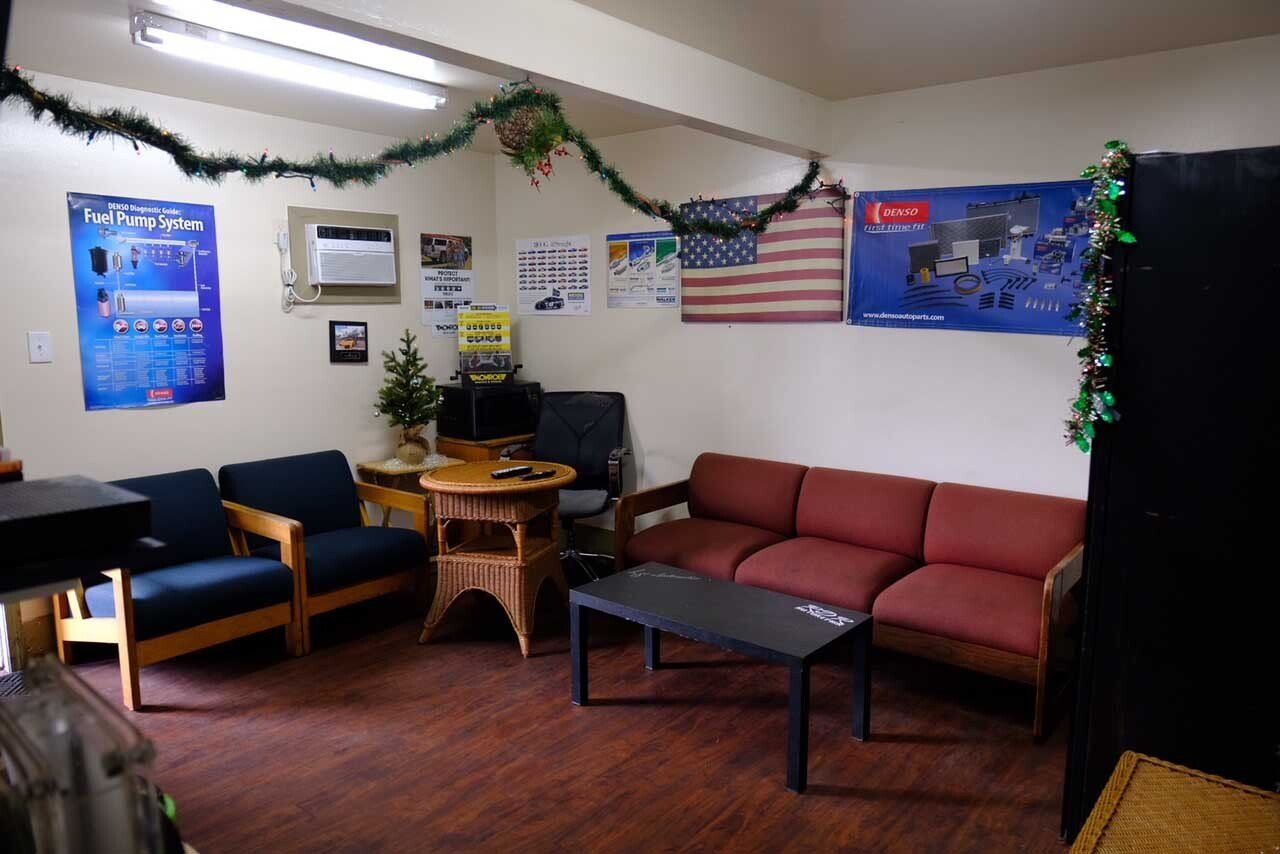 Cozy waiting room with chairs, sofa, table, wall posters, and string lights