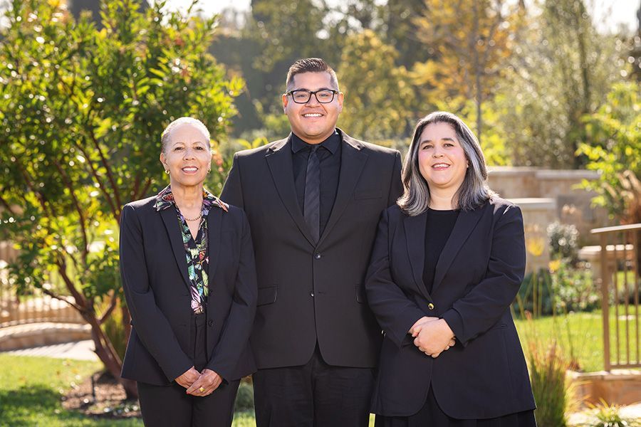 A man and two women in suits are posing for a picture.