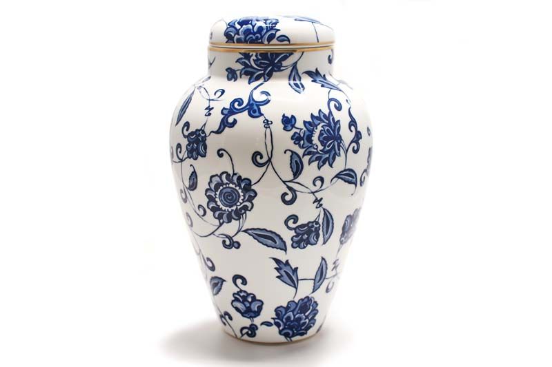 A blue and white vase with flowers on it
