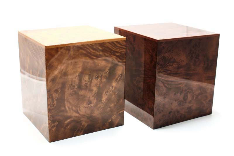 Two wooden cubes are sitting next to each other on a white surface.