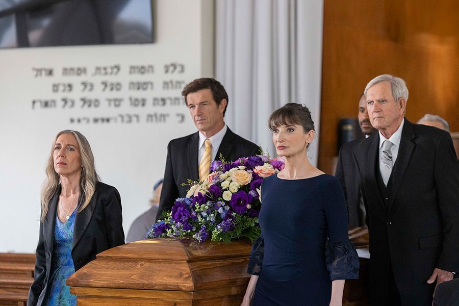 A group of people are standing around a coffin in a church.