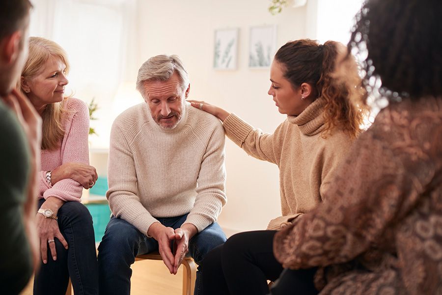 A group of people are sitting in a circle and talking to each other.