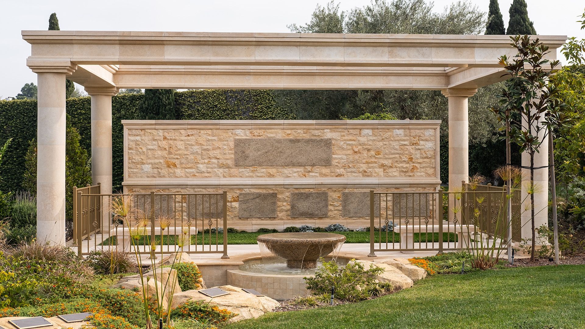 A stone wall with a fountain in front of it
