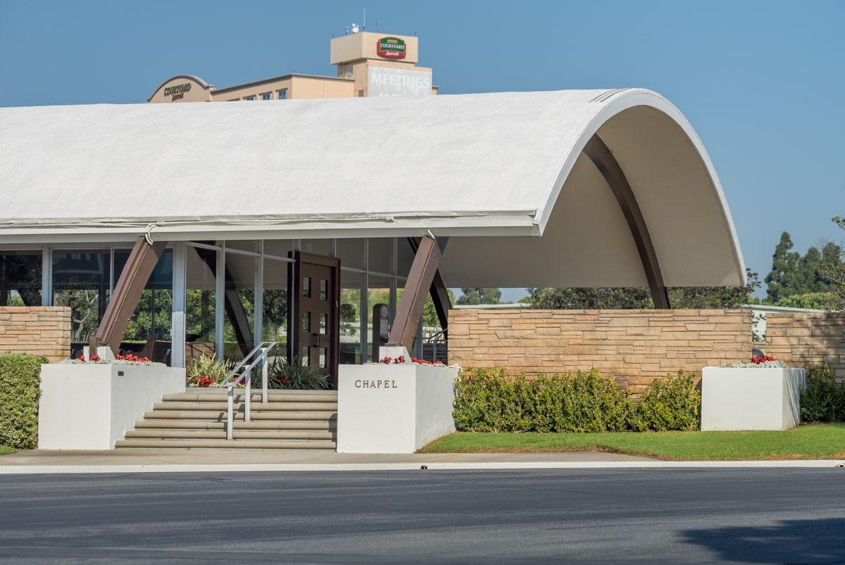 A large white building with a curved roof and stairs leading up to it.